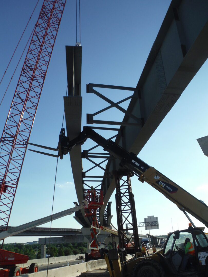 A crane is lifting the steel girders of a bridge.