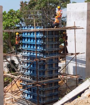 A group of men working on the top of a building.