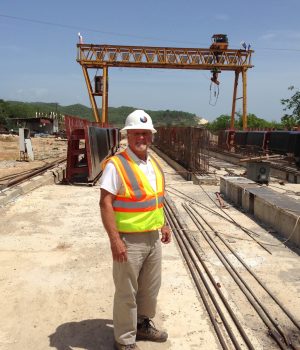 A man in safety gear standing on the tracks.