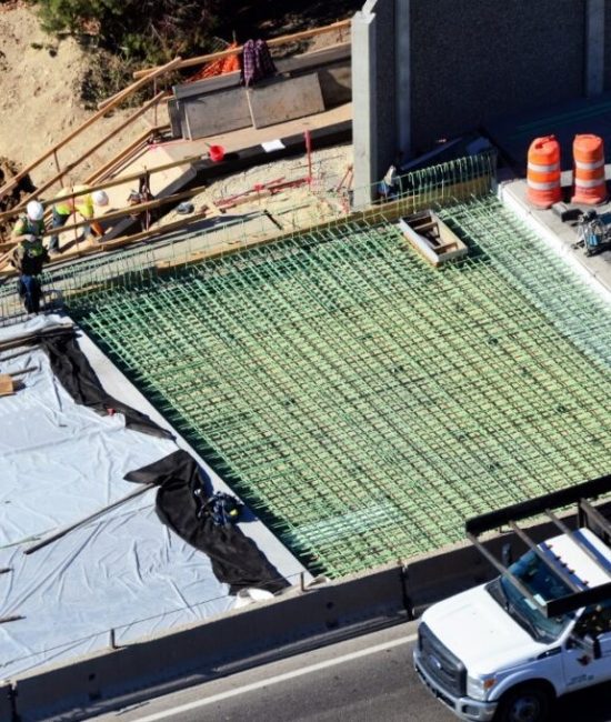 A construction site with workers and equipment on the roof.