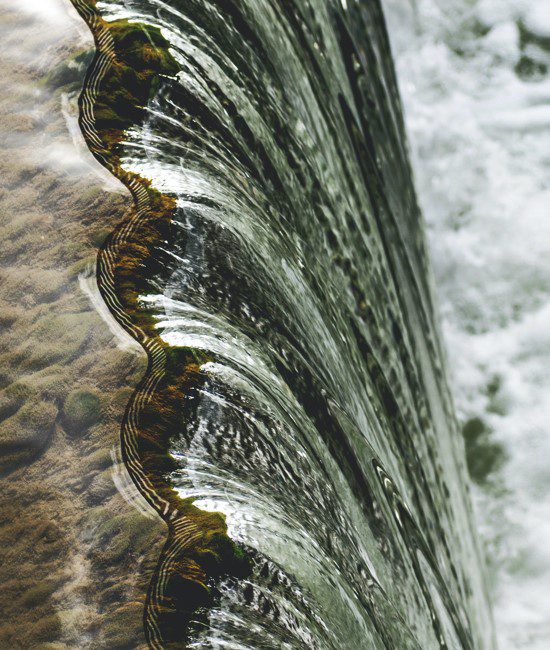 A close up of the water on the side of a waterfall.