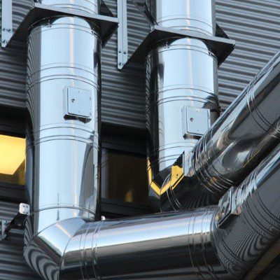 A close up of the outside of a building with many pipes.