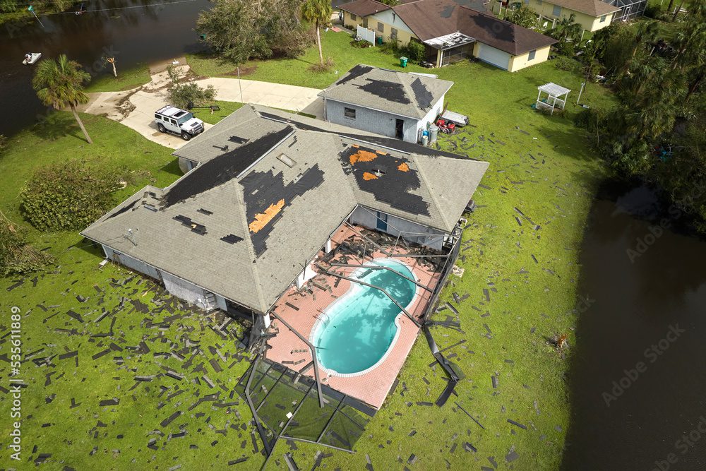 House with damaged roof and pool enclosure. House with damaged roof and pool enclosure.