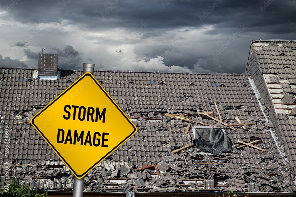 Storm damage sign and damaged roof. Storm damage sign and damaged roof.