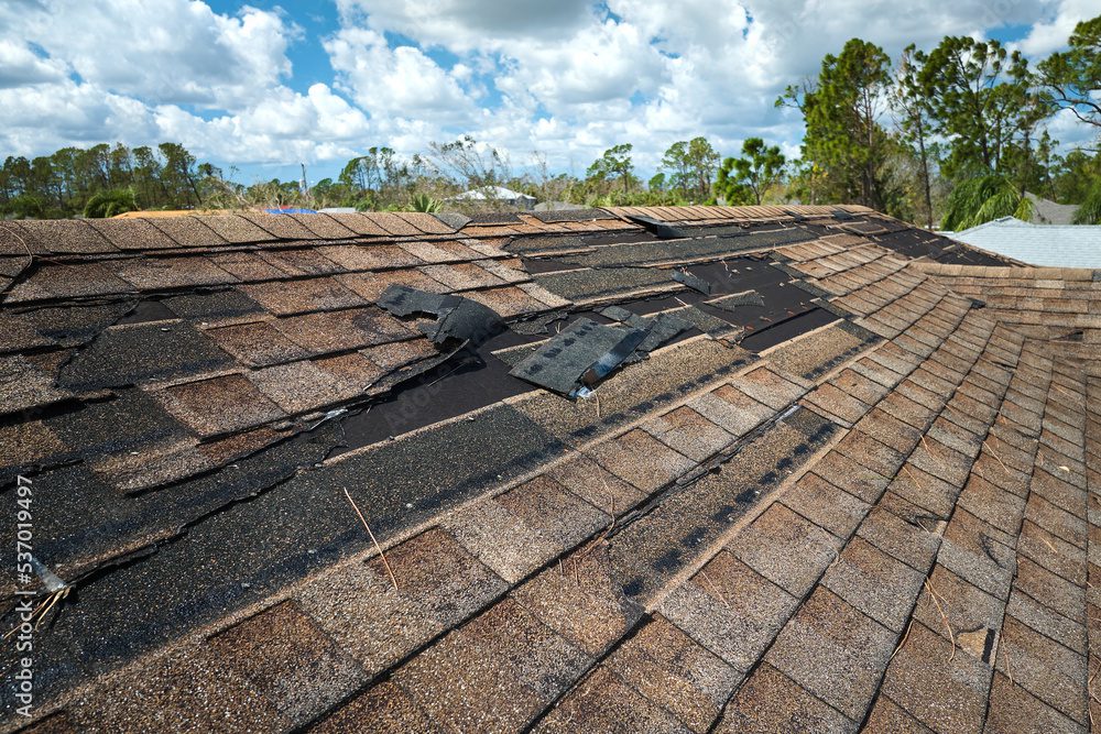 Damaged roof with missing shingles, cloudy sky. Damaged roof with missing shingles, cloudy sky.